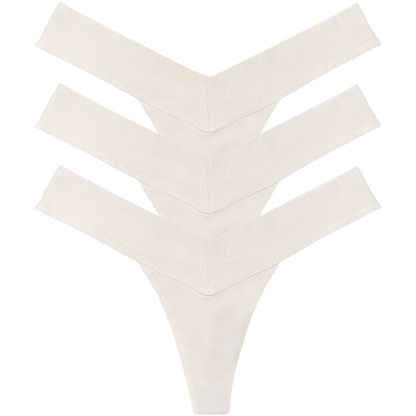 Set of three cream-colored thong underwear pieces on a white background